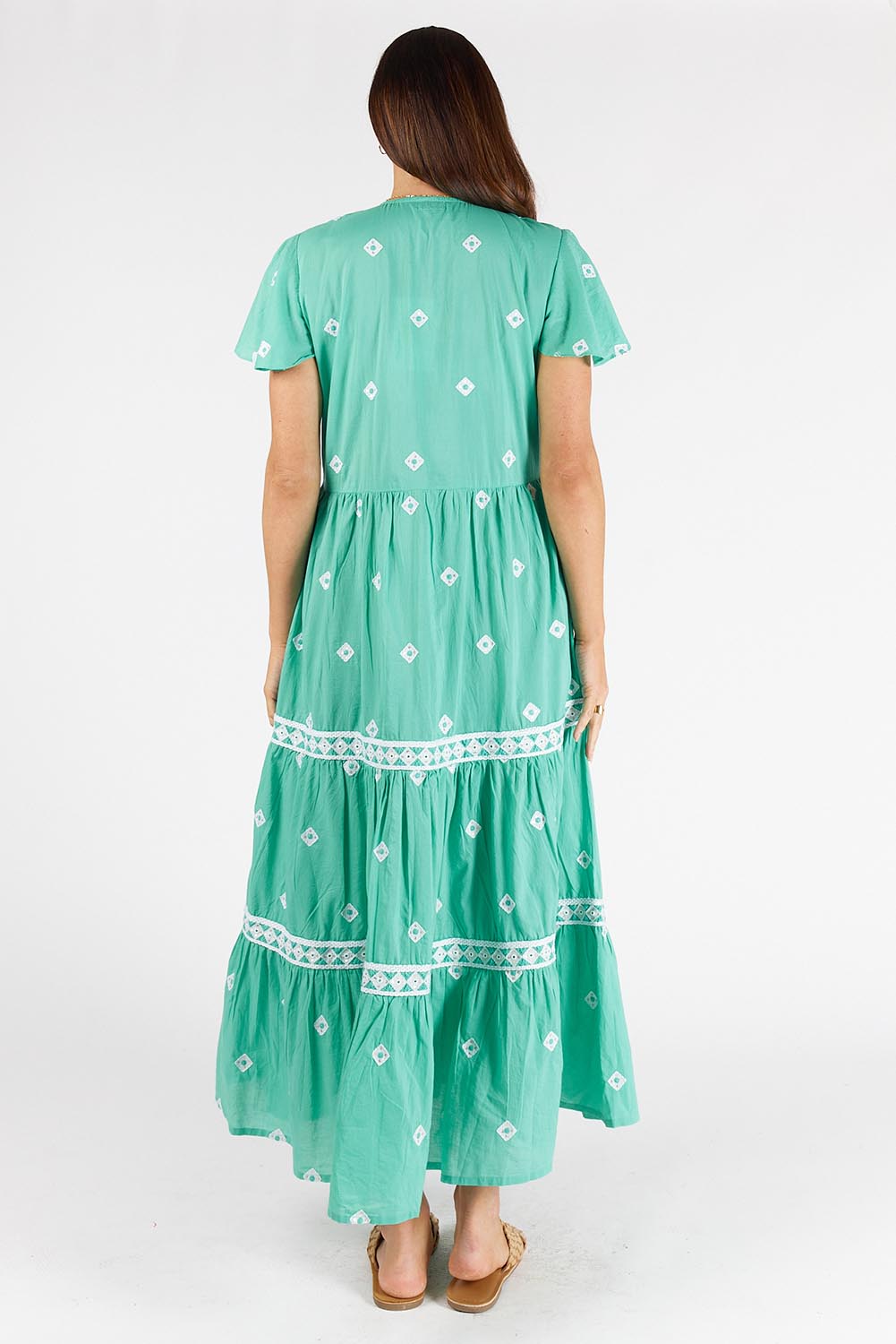 A model wearing the Antigua Maxi Cotton Dress in colour Sea (Green), from the back
