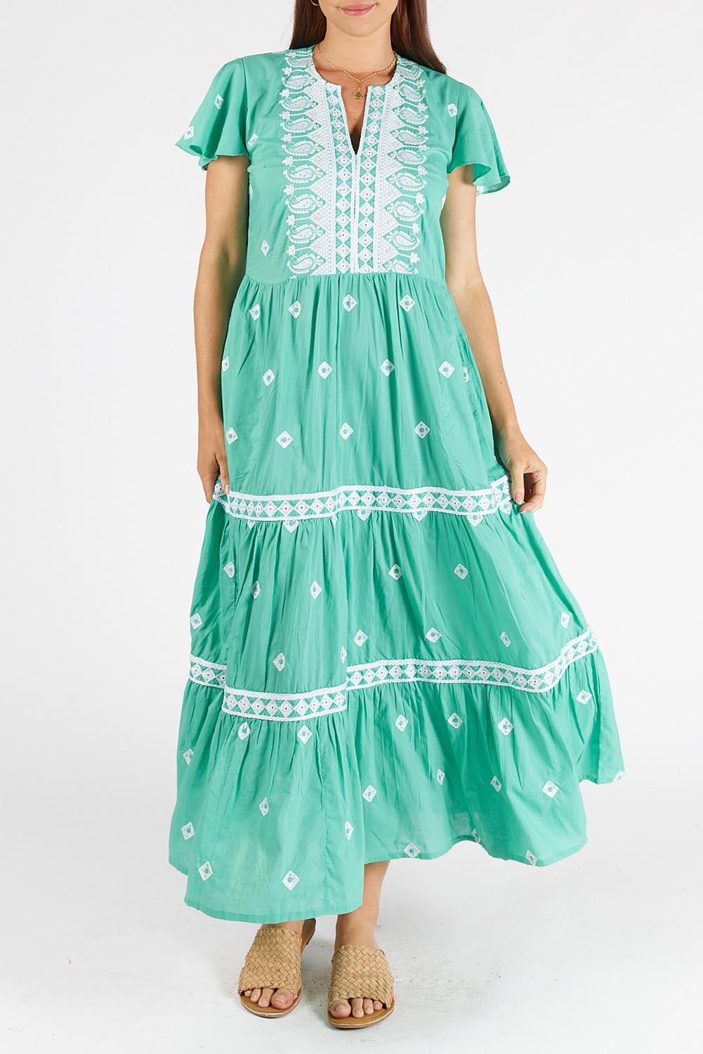 A model wearing the Antigua Maxi Cotton Dress in colour Sea (Green), from the front, cropped image
