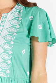 A model wearing the Antigua Maxi Cotton Dress in colour Sea (Green), from the front, cropped image
