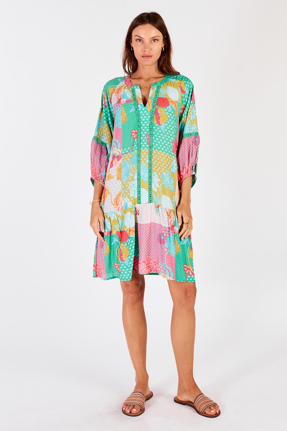 A model wearing the Camargue Dress in colour Lagoon (Green), from the front, showing the whole outfit