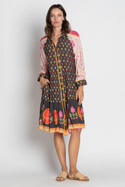 A model wearing the Grenadine Dress in colour Truffle, from the front, showing the whole outfit