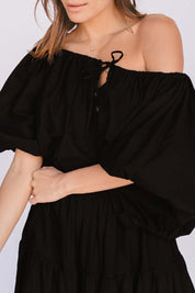 A model wearing the Kaira Top in colour Jett (Black), from the front, cropped image