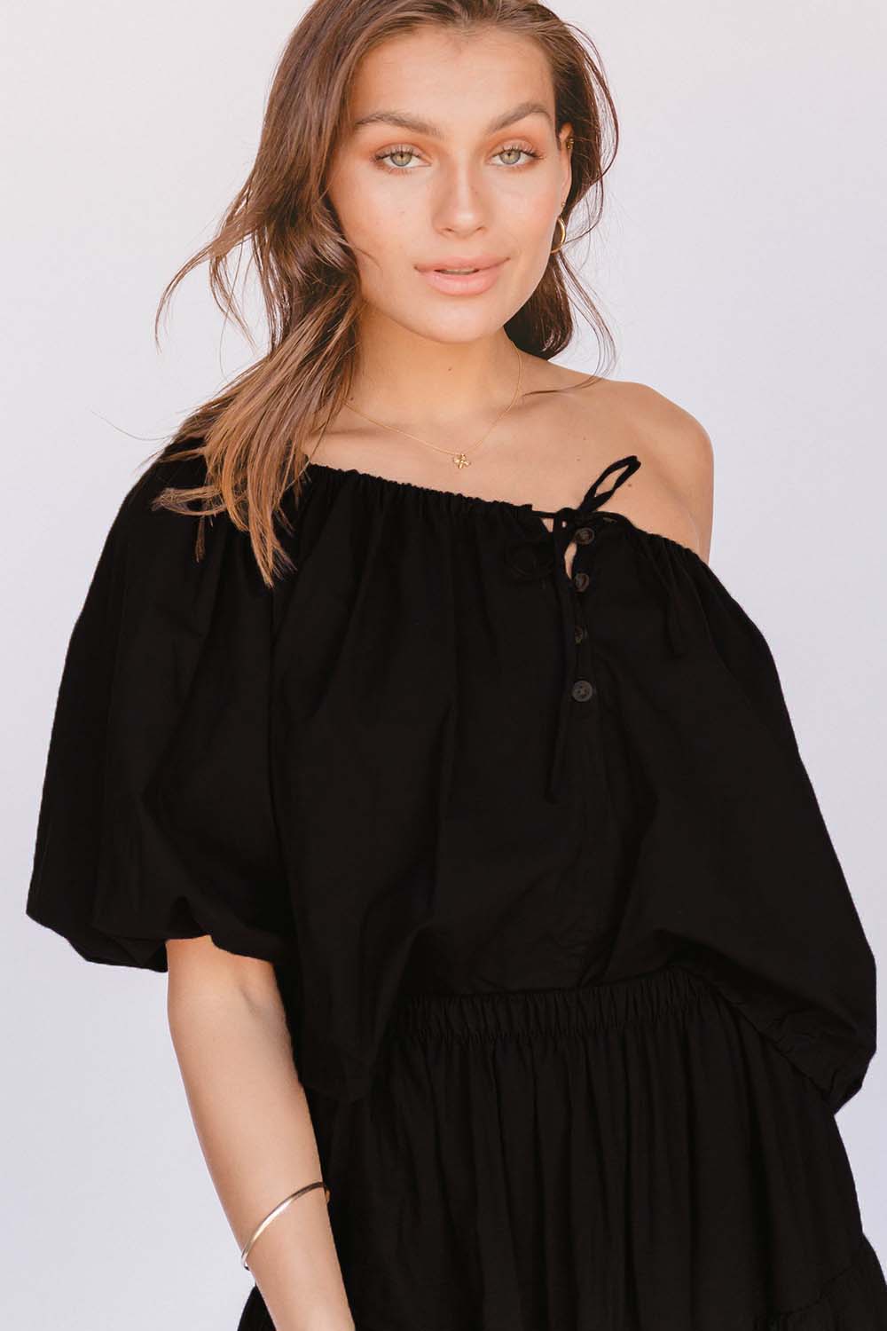 A model wearing the Kaira Top in colour Jett (Black)