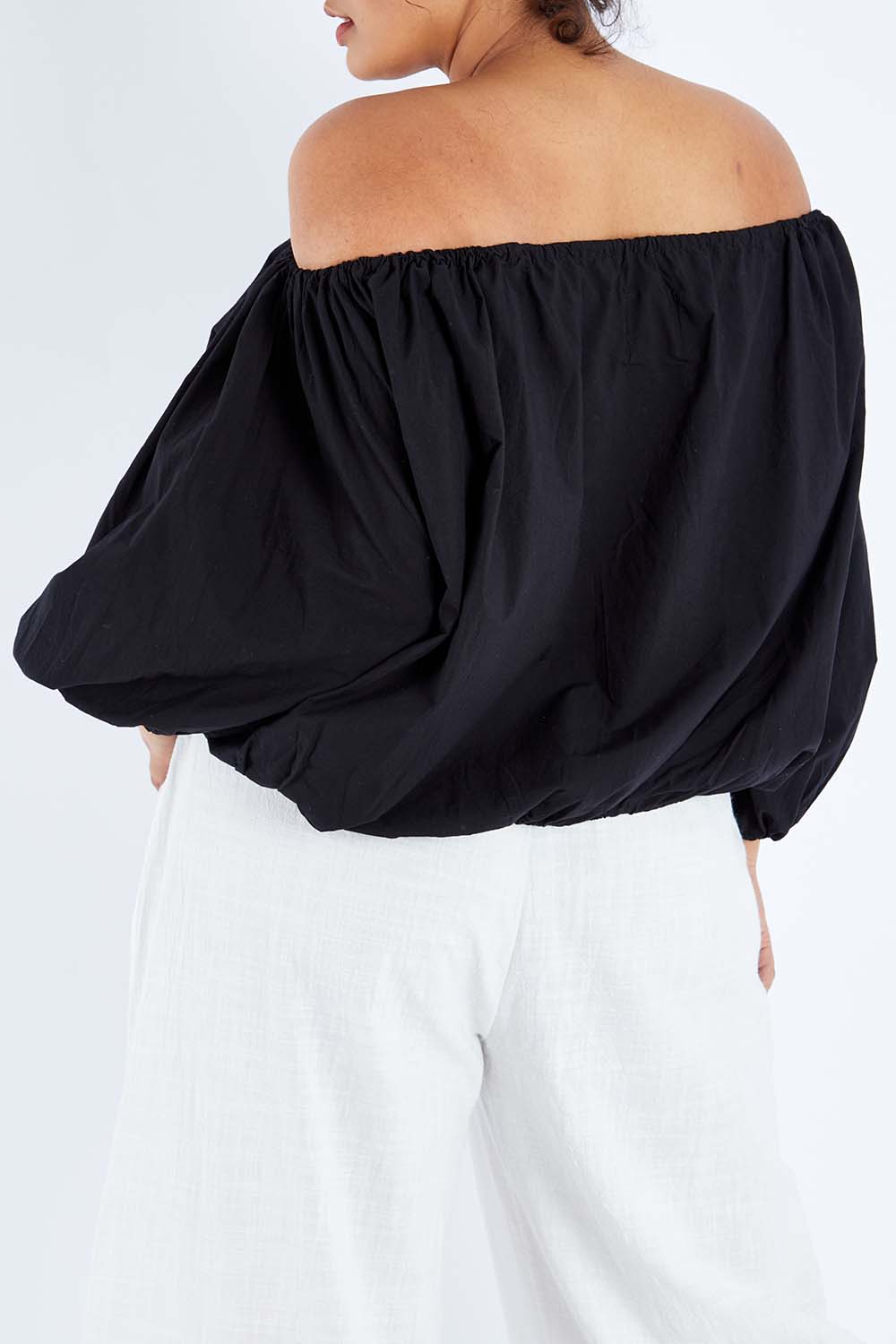 Model Sasha-Lee wearing the Kaira Top in colour Jett (Black), from the back