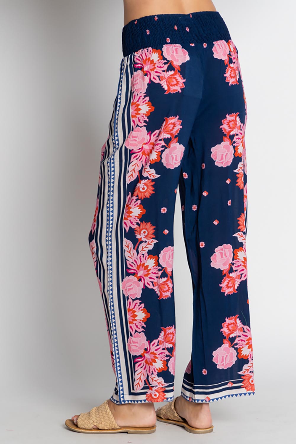 A model wearing the Ladera Pant in colour Navy (Blue), from the back