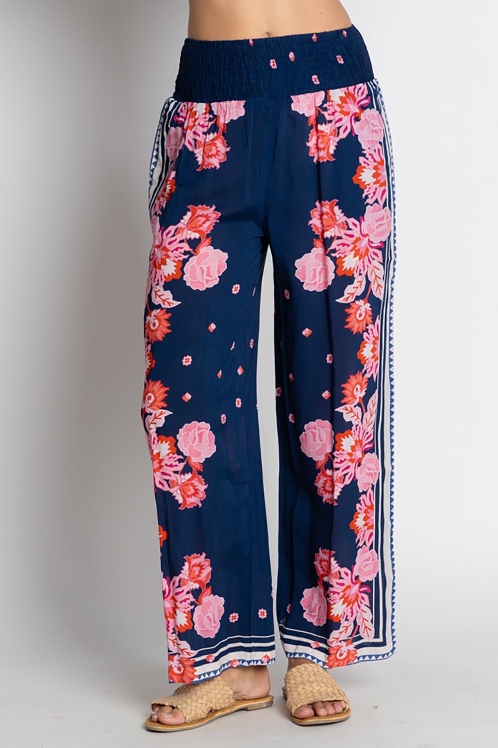 A model wearing the Ladera Pant in colour Navy (Blue), from the front, cropped image