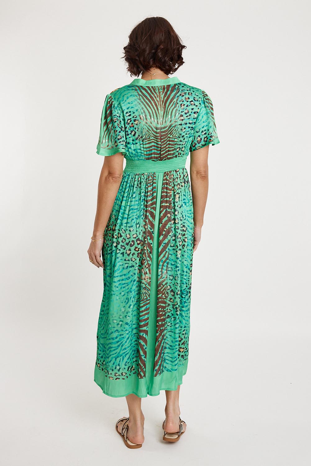 A model wearing the Maasai Midi Dress in colour Emerald (Green), from the back