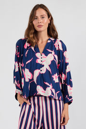 Model Genericm wearing size sample of the Palmilla Floral Top – Navy in colour Navy, in a cropped view
