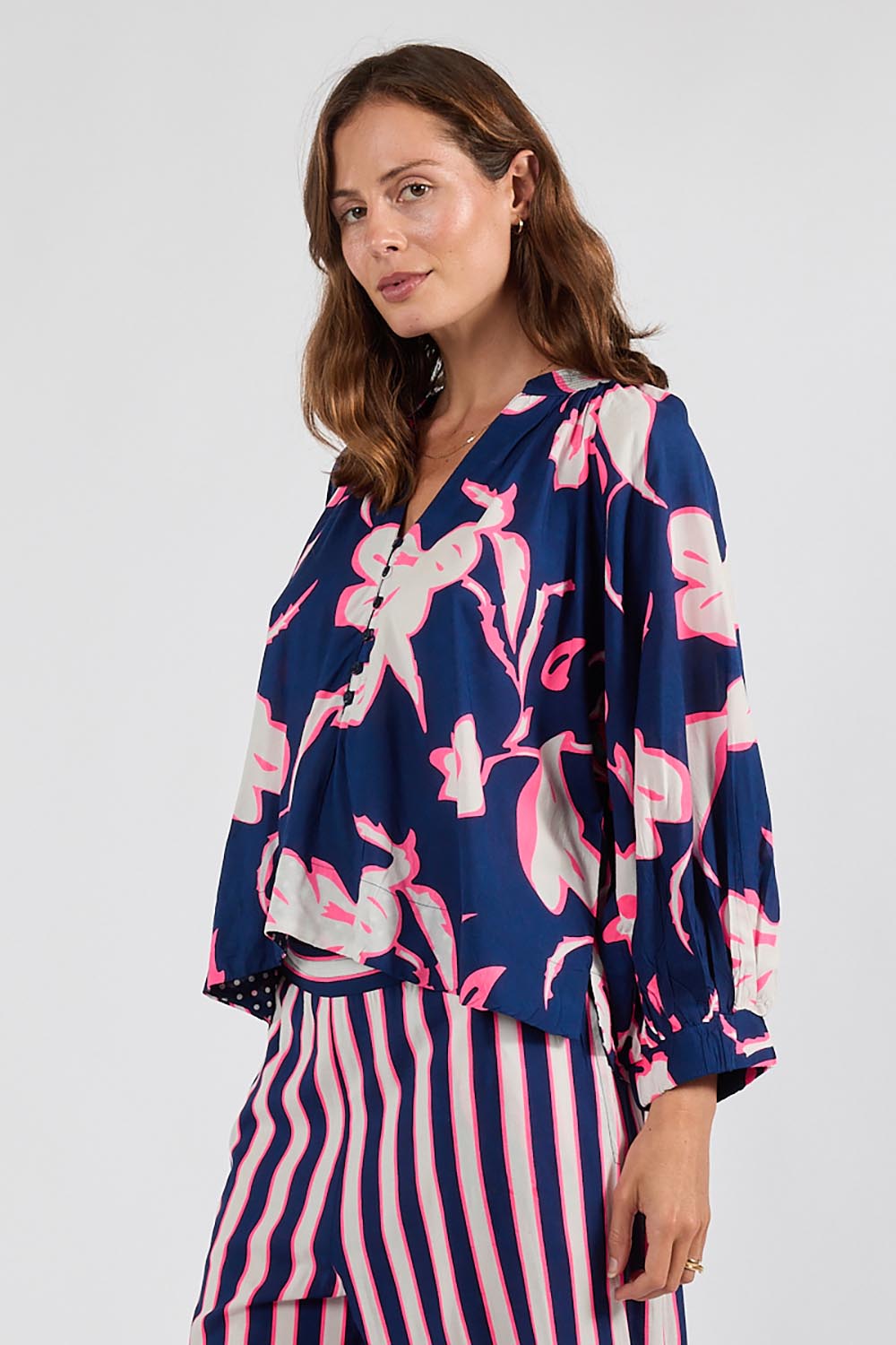 Model Genericm wearing size sample of the Palmilla Floral Top – Navy in colour Navy, in a cropped view