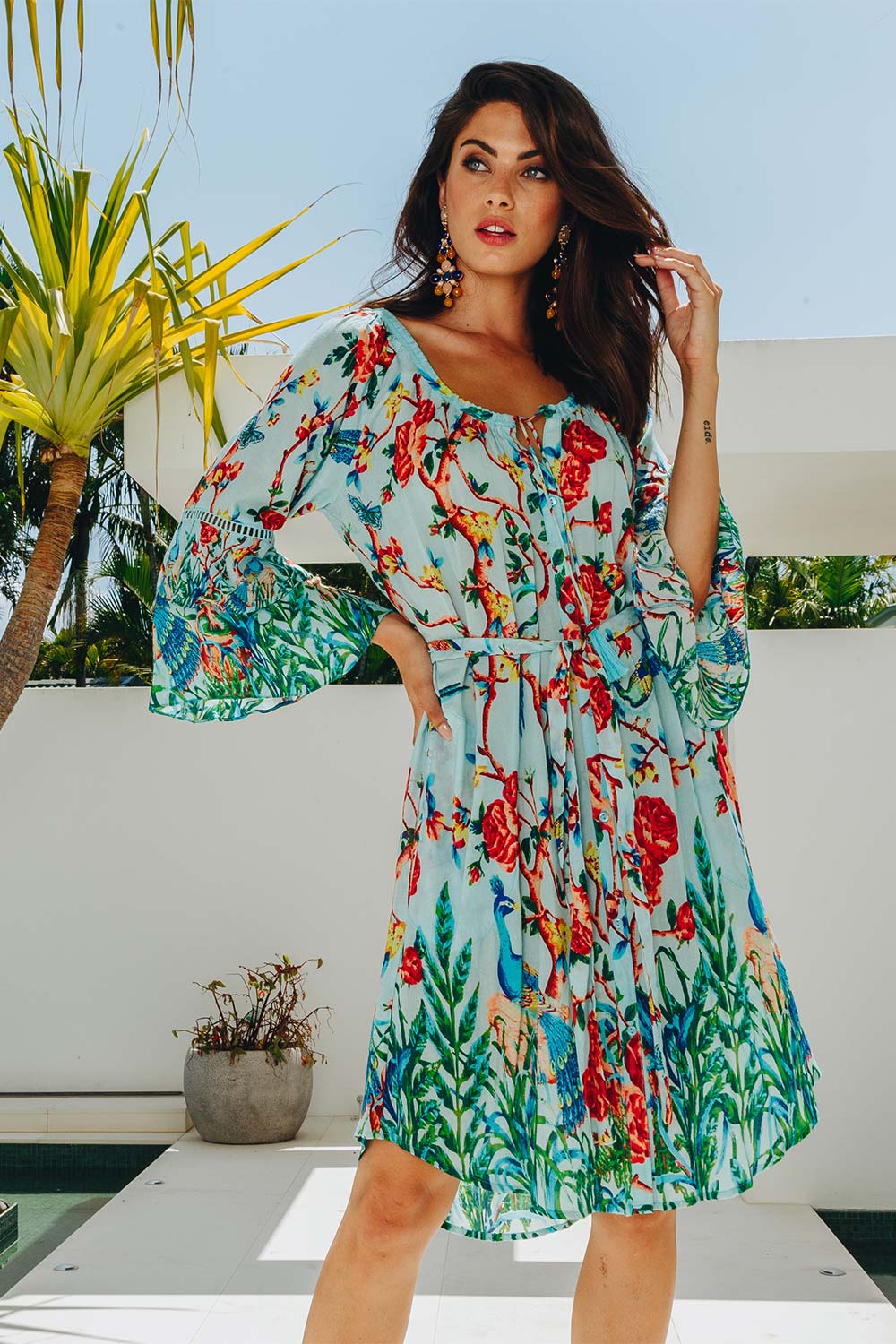 A model wearing the Peacock Dress in colour Mint (Blue), from the front, showing the whole outfit