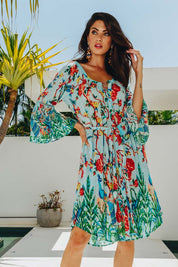 A model wearing the Peacock Dress in colour Mint (Blue), from the front, showing the whole outfit