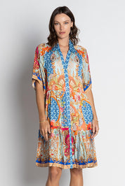 A model wearing the Le Sereno Dress in colour Ocean, from the front, cropped image