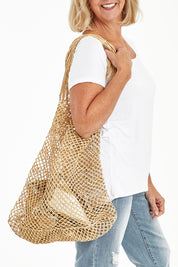 Model Sandy wearing size OneSize of the Malala Bag in colour Natural, from the front, cropped image