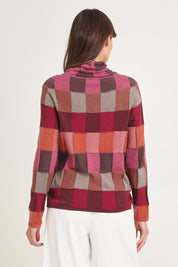 Model Madeline wearing size S of the Lindi Organic Cotton Sweater in colour Spice (Pink), from the back