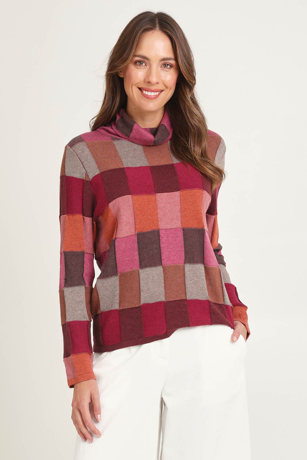 Model Madeline wearing size S of the Lindi Organic Cotton Sweater in colour Spice (Pink), from the front, cropped image