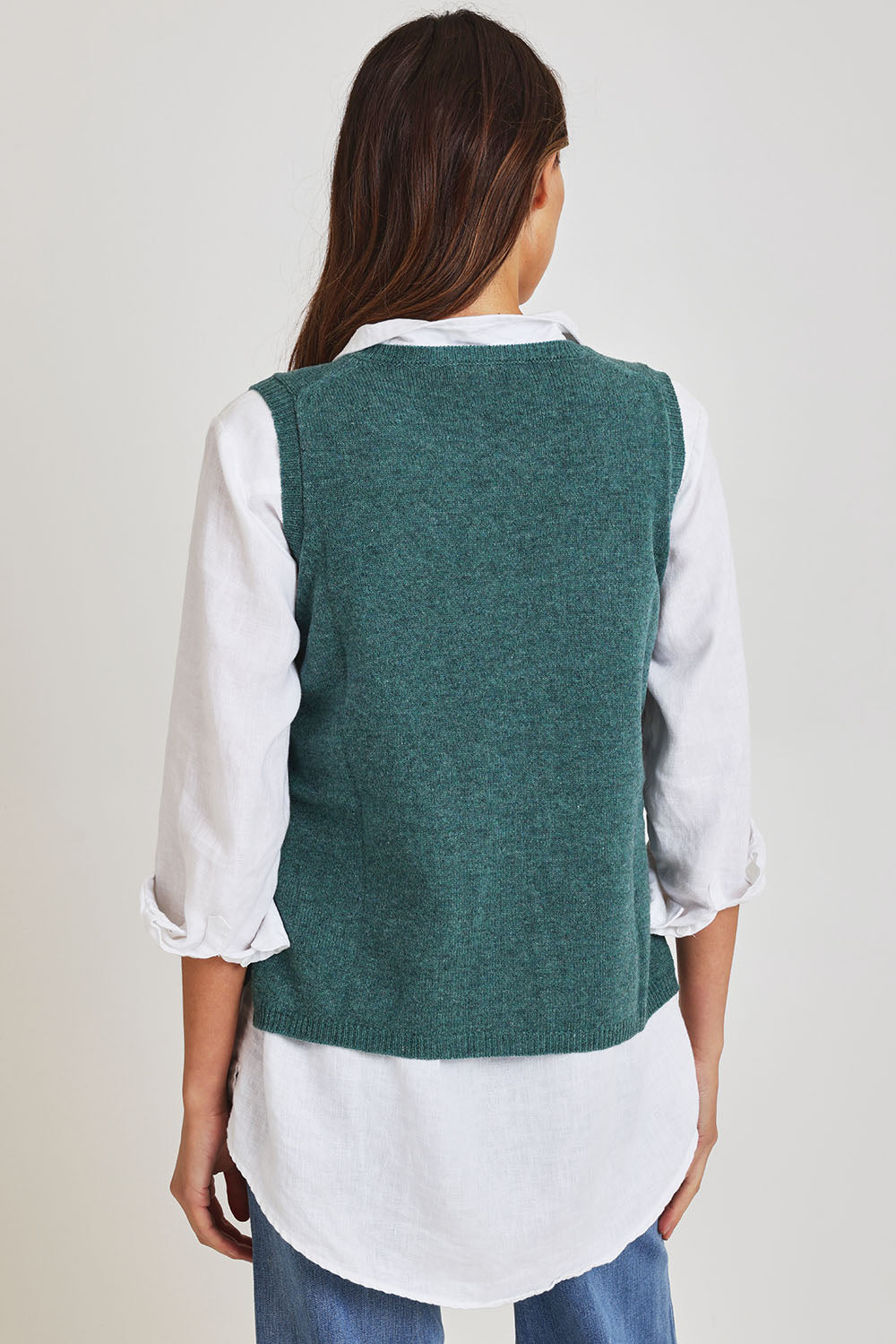 Model Madeline wearing size S of the Mitos Vest in colour Darksea (Green), from the back