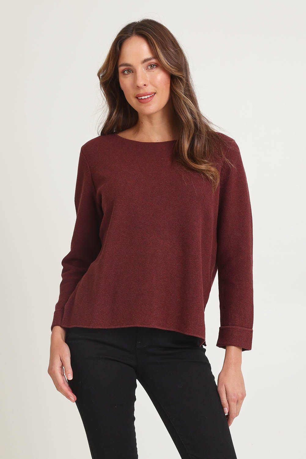 Model Madeline wearing size S of the Moriko Sweater in colour Spice, from the front, cropped image