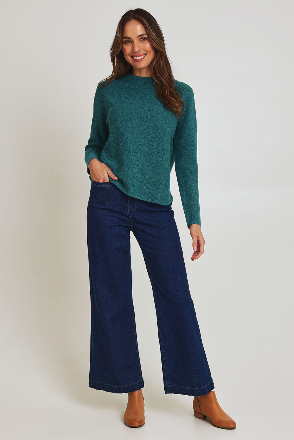 Model Madeline wearing size S of the Mosque Sweater in colour Sea (Green), from the front, showing the whole outfit