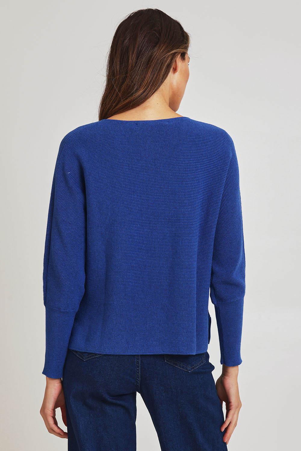 Model Madeline wearing size S of the Neria Organic Cotton Sweater in colour Blue (Blue), from the back