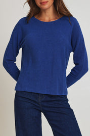 Model Madeline wearing size S of the Neria Organic Cotton Sweater in colour Blue (Blue), from the front, cropped image