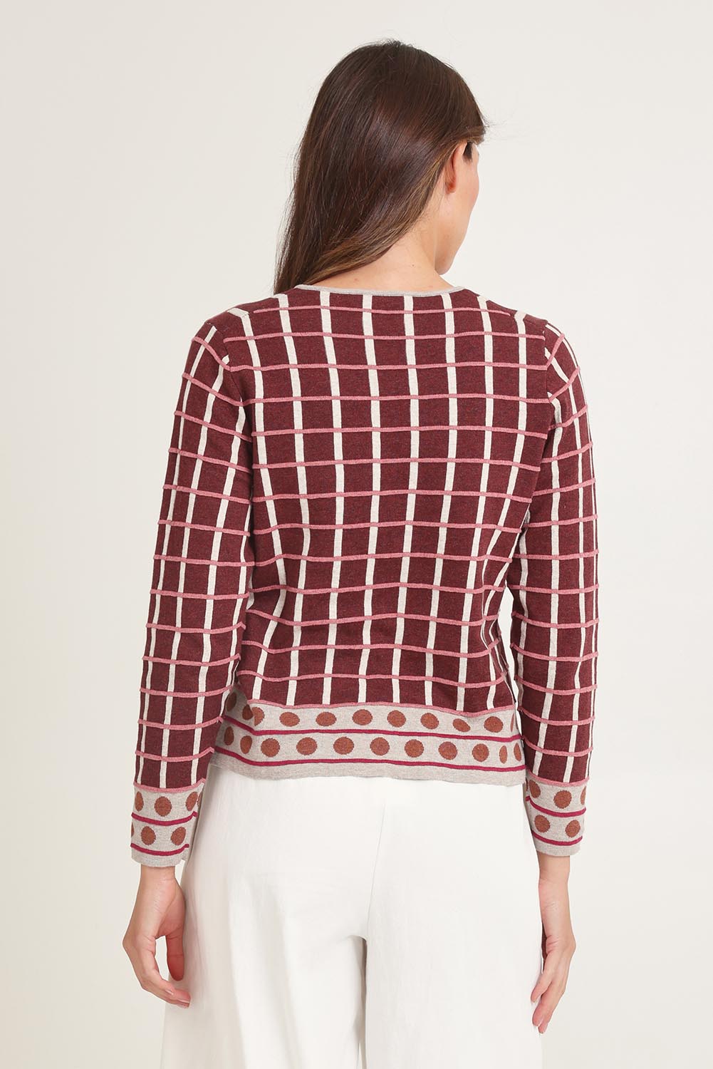 Model Madeline wearing size S of the Odette Organic Cotton Cardigan in colour Spice (Red), from the back