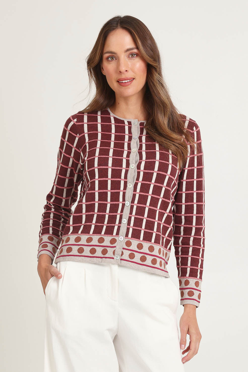 Model Madeline wearing size S of the Odette Organic Cotton Cardigan in colour Spice (Red), from the front, cropped image