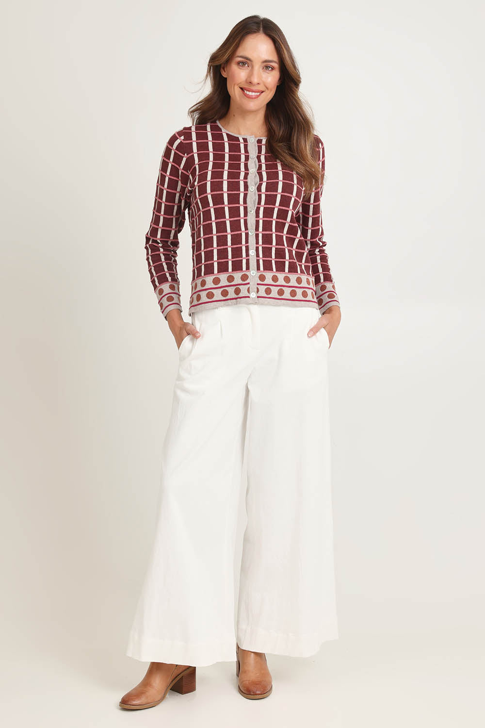 Model Madeline wearing size S of the Odette Organic Cotton Cardigan in colour Spice (Red), from the front, showing the whole outfit