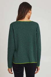 Model Madeline wearing size S of the Paprika Reversible Organic Cotton Sweater in colour Darkgreen (Green), from the back