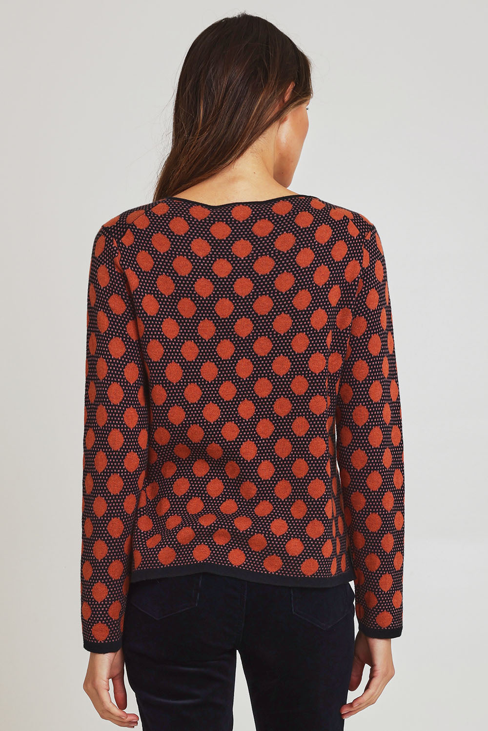 Model Madeline wearing size S of the Sne Organic Cotton Cardigan in colour Rust, from the back