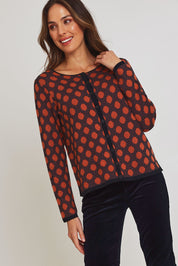 Model Madeline wearing size S of the Sne Organic Cotton Cardigan in colour Rust, from the front, cropped image