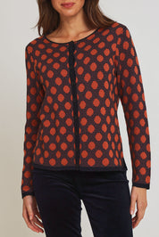 Model Madeline wearing size S of the Sne Organic Cotton Cardigan in colour Rust, from the front, cropped image