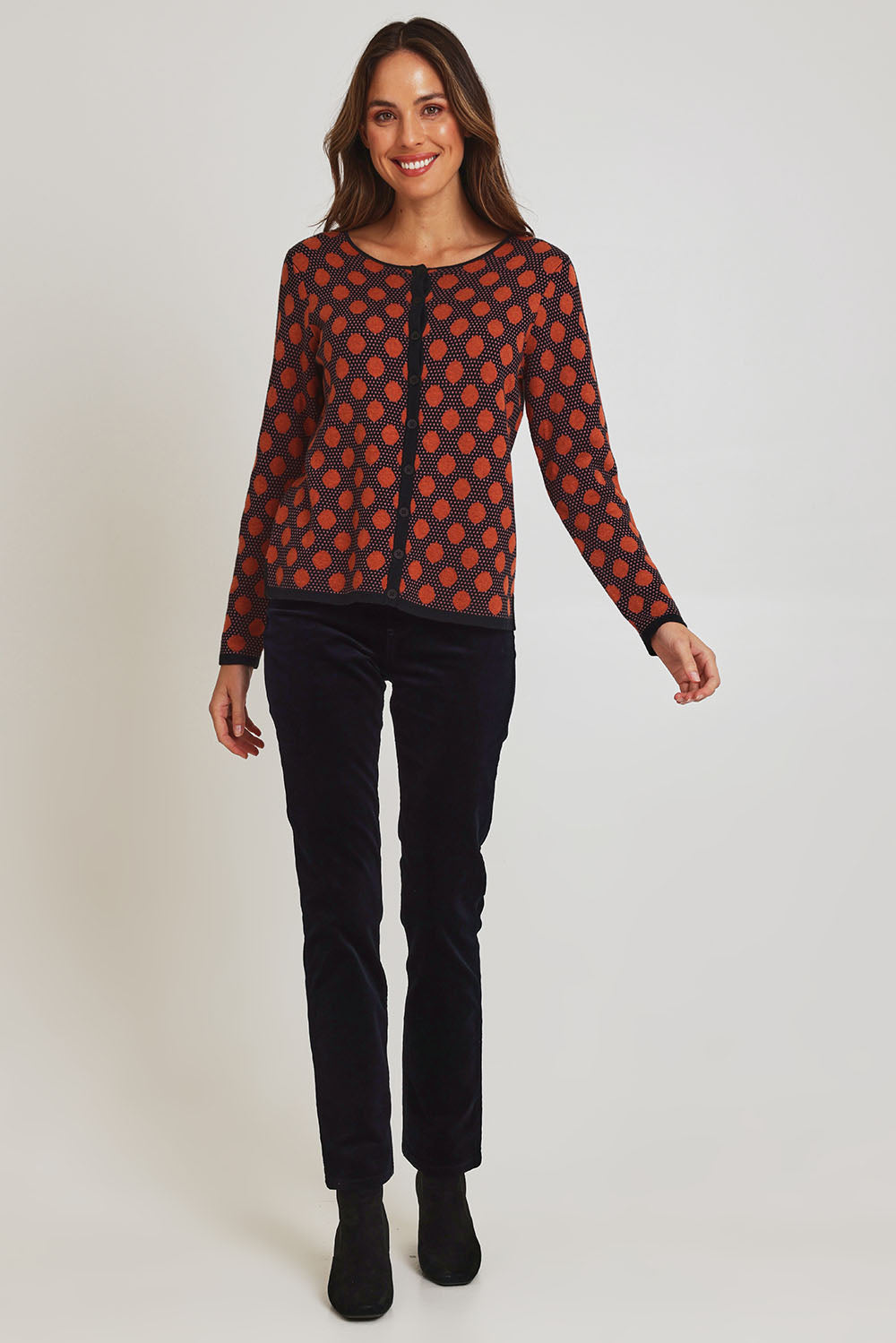 Model Madeline wearing size S of the Sne Organic Cotton Cardigan in colour Rust, from the front, showing the whole outfit