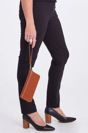 Model Sandy wearing size OneSize of the Elm Vegan Zip Around Wallet in colour Chili, from the front, cropped image