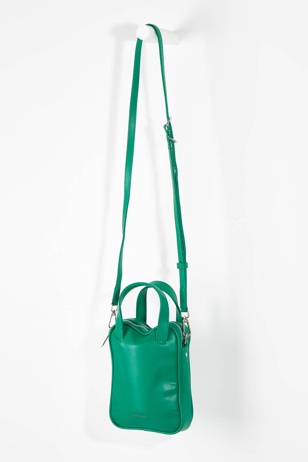 A model wearing size OneSize of the Leap Vegan Crossbody Bag in colour Peacock (Green), from the front, showing the whole outfit