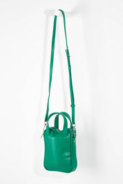 A model wearing size OneSize of the Leap Vegan Crossbody Bag in colour Peacock (Green), from the front, showing the whole outfit