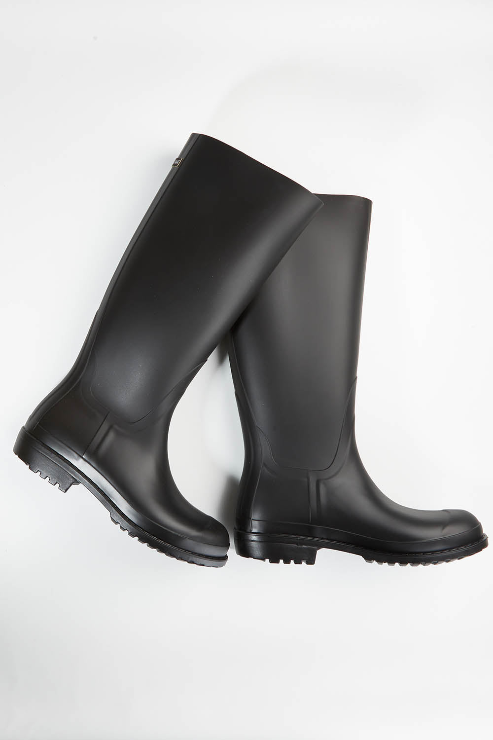 A model wearing size 36 of the Otoki Waterboot Calf Rainboot in colour Black (Black), from the front, showing the whole outfit