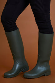 A model wearing size 40 of the Otoki Waterboot Calf Rainboot in colour Olive (Green), from the front, cropped image