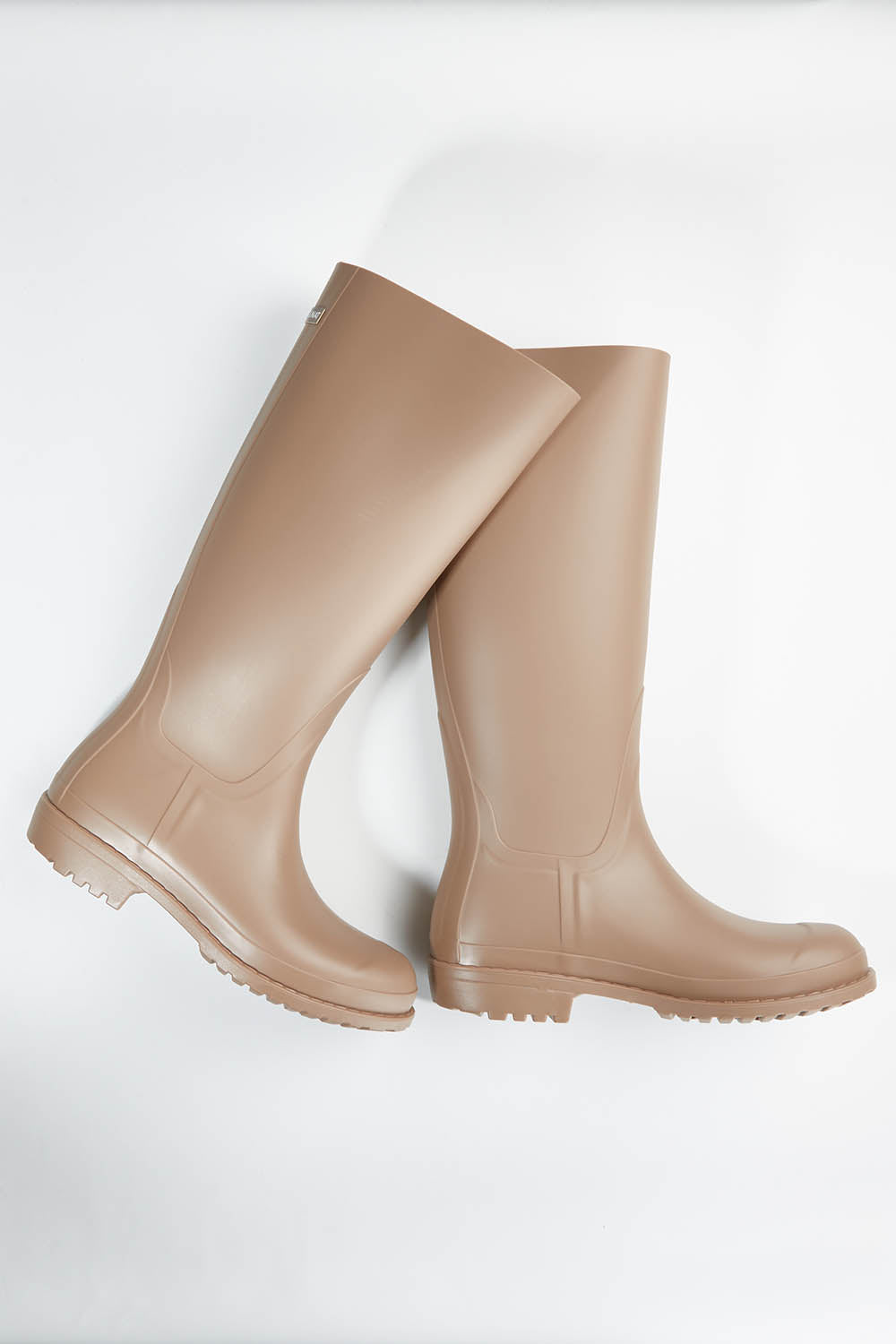 A model wearing size 36 of the Otoki Waterboot Calf Rainboot in colour Soy, from the front, showing the whole outfit