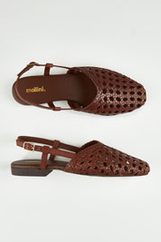 A model wearing size 37 of the Drasa Leather Woven Flat Heel in colour Chocolate, from the front, showing the whole outfit
