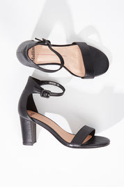 A model wearing size 36 of the Gessie Heel in colour Black (Black), from the front, showing the whole outfit