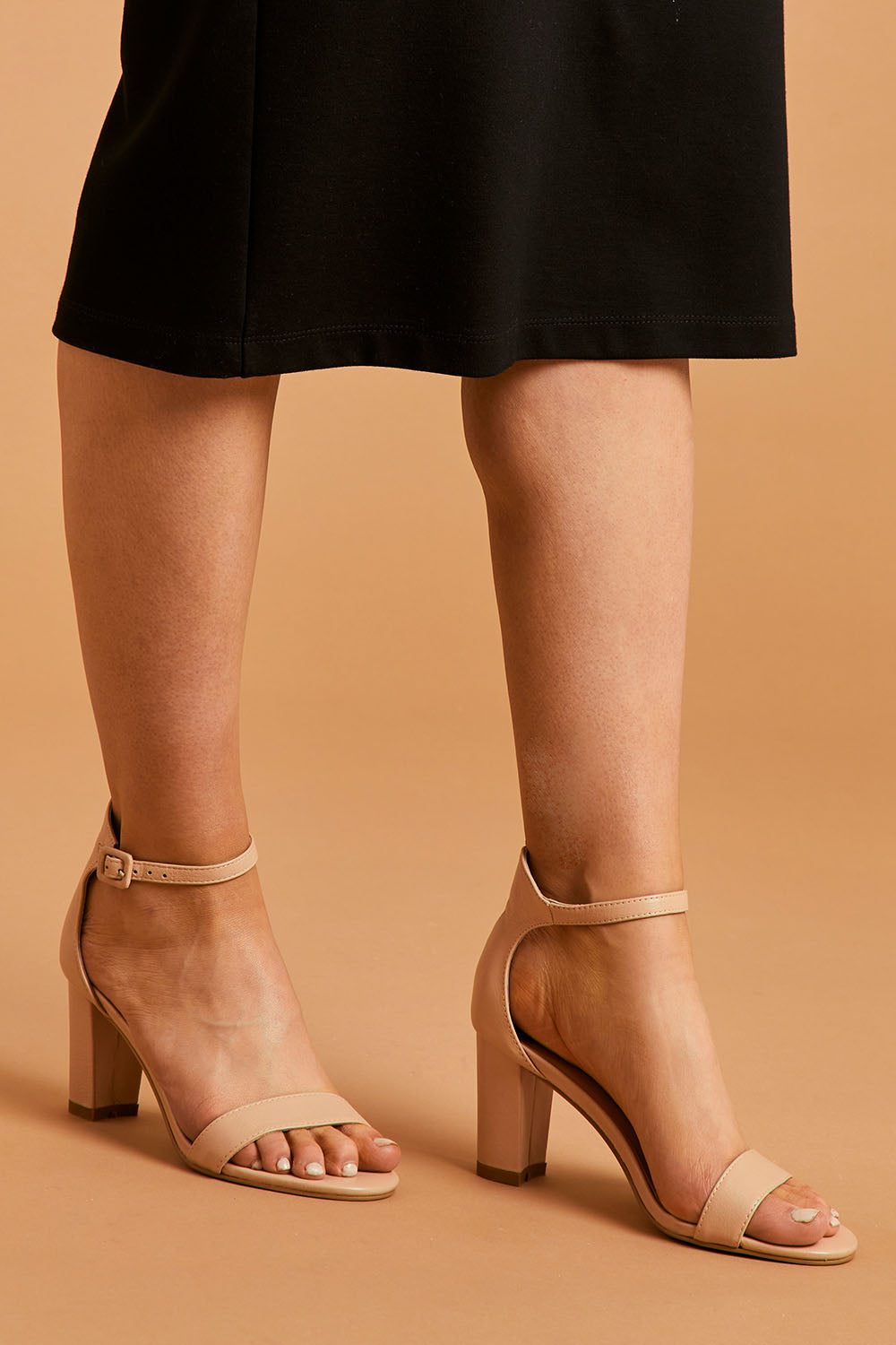 A model wearing size 38 of the Gessie Heel in colour Nude, from the front, cropped image