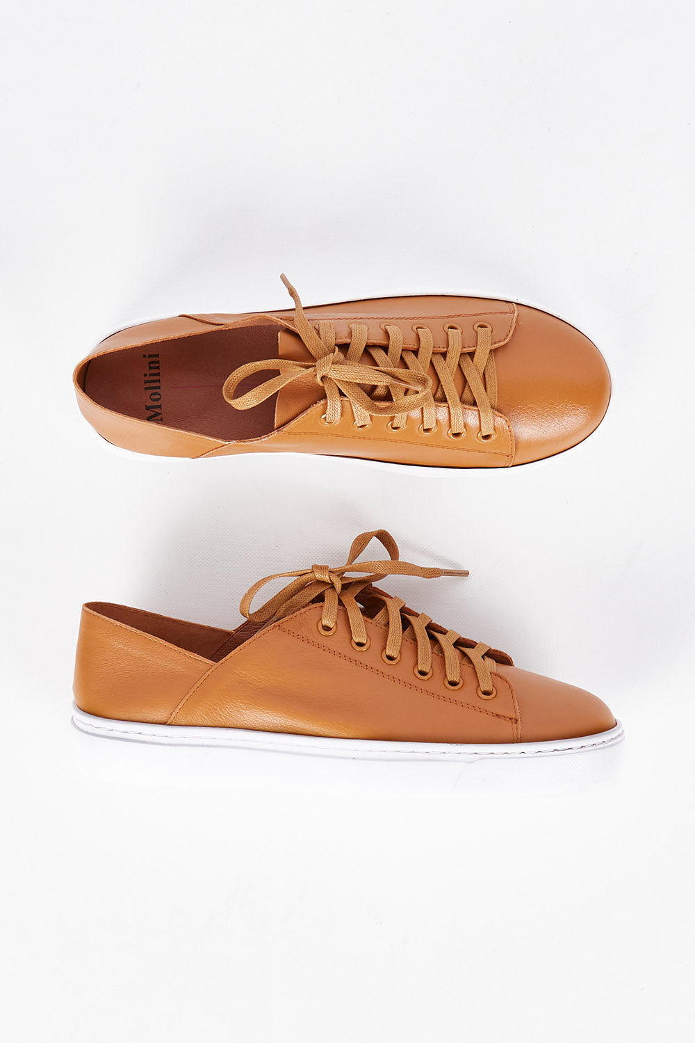 A model wearing size 36 of the Oskher Leather Sneaker in colour Dktan, from the front, showing the whole outfit