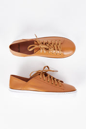 A model wearing size 36 of the Oskher Leather Sneaker in colour Dktan, from the front, showing the whole outfit