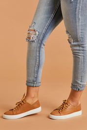 A model wearing size 38 of the Oskher Leather Sneaker in colour Dktan, from the front, cropped image
