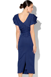 A model wearing the Monelli Rosette Sleeve Dress in colour Navy (Blue), from the back