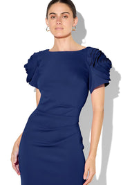 A model wearing the Monelli Rosette Sleeve Dress in colour Navy (Blue), from the front, cropped image