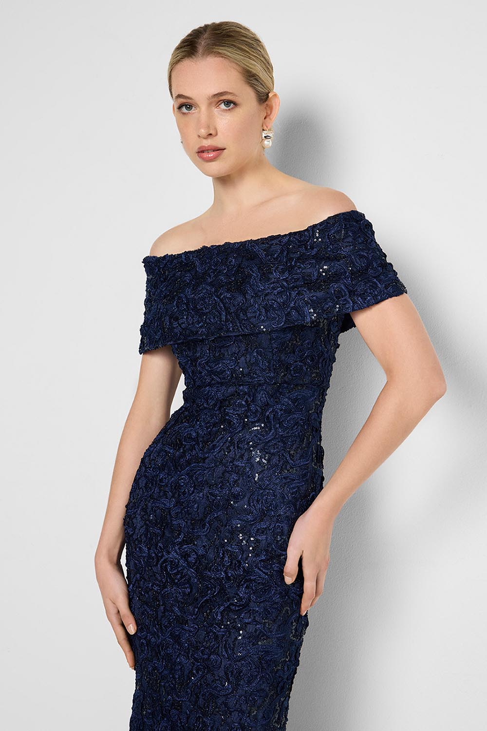 Model Genericm wearing size sample of the Emerson Off The Shoulder Gown - Navy in colour Navy, from an angle