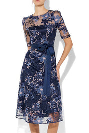 A model wearing the Loren Lace Midi Dress in colour Navypink (Blue), from the front, cropped image