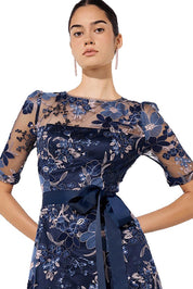 A model wearing the Loren Lace Midi Dress in colour Navypink (Blue), from the front, cropped image