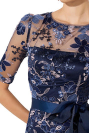 A model wearing the Loren Lace Midi Dress in colour Navypink (Blue), from the front, cropped image